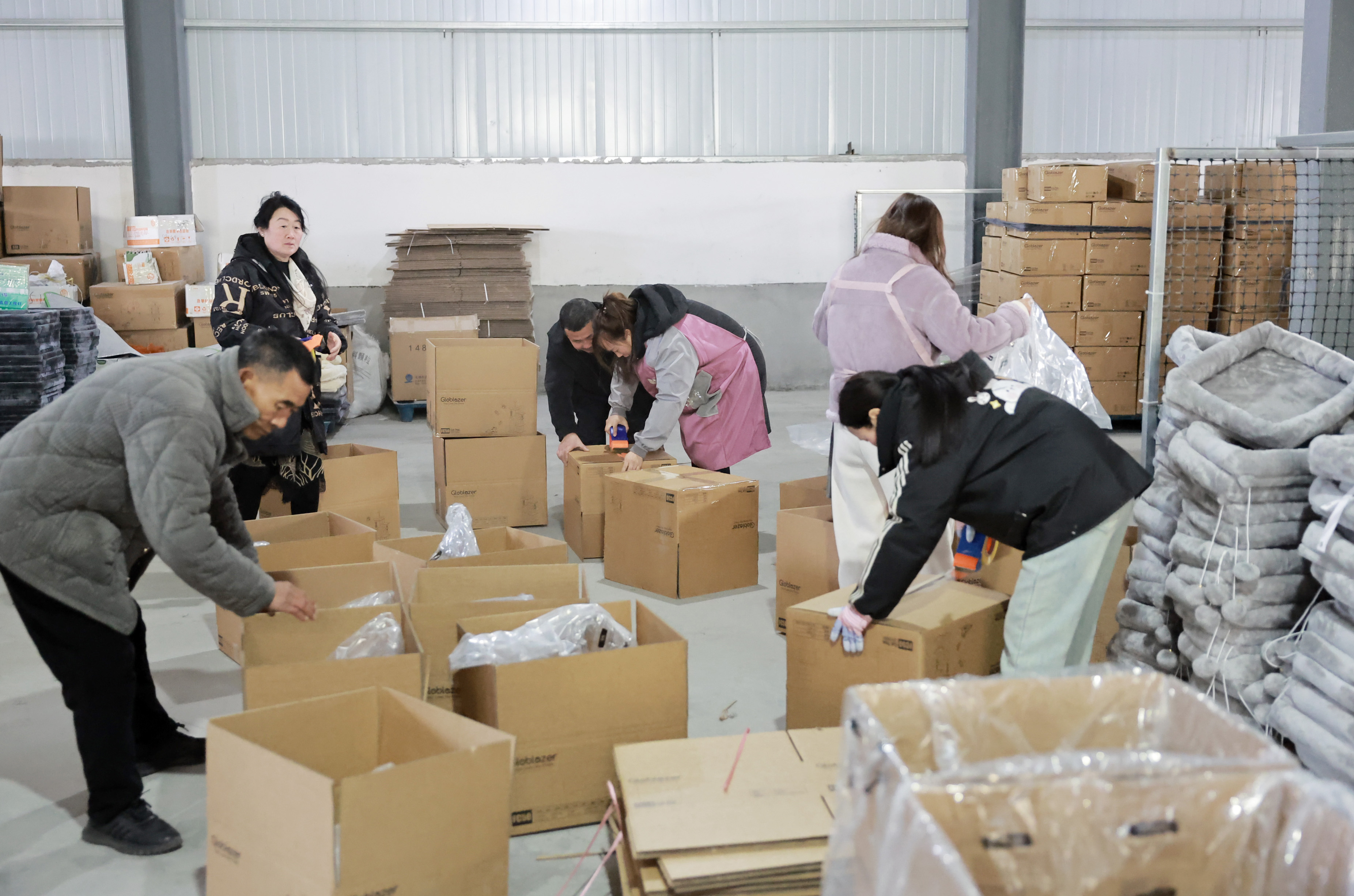 工人忙着包装猫爬架产品。 工人忙着包装猫爬架产品。