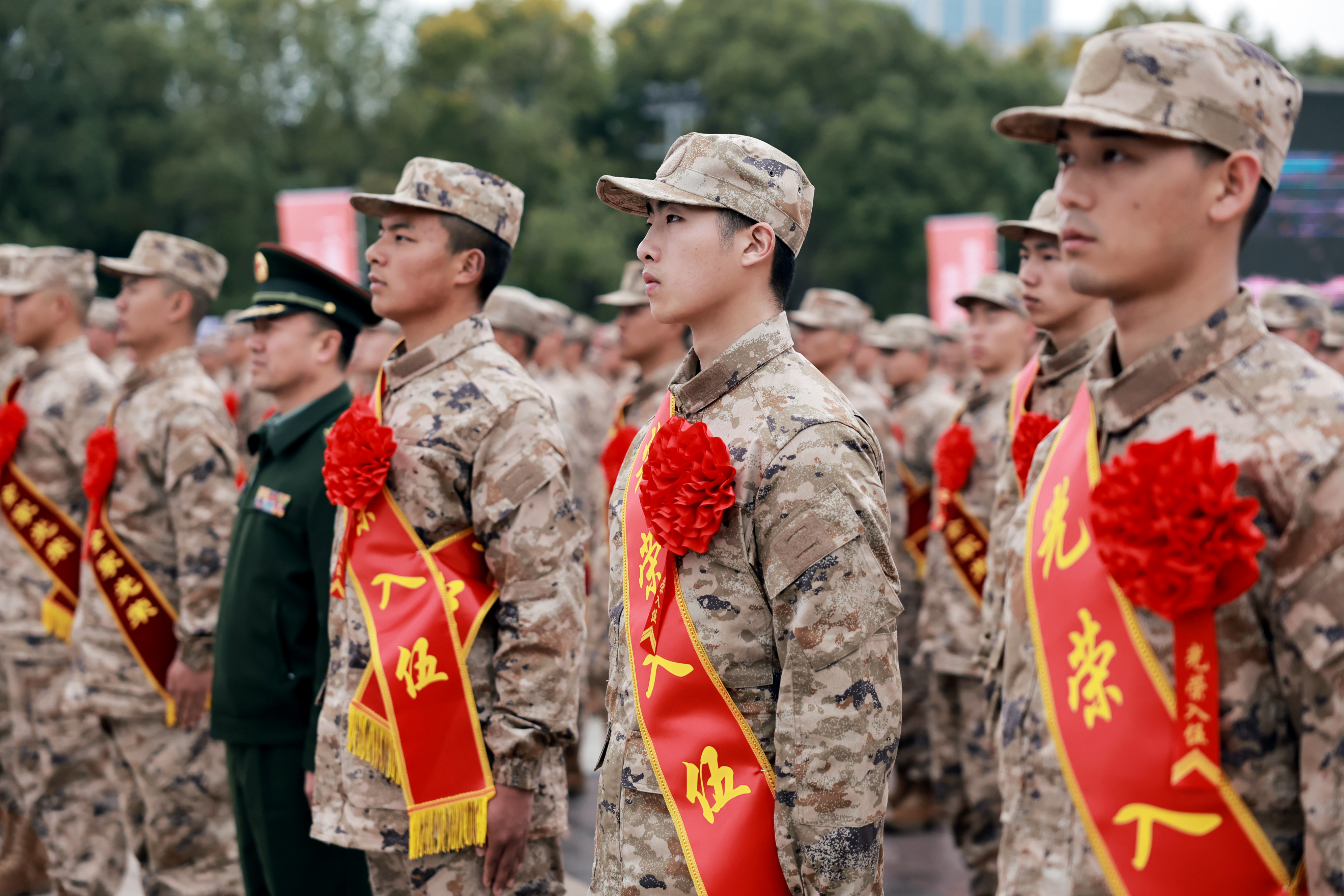 入伍新兵肩披鲜红绶带。