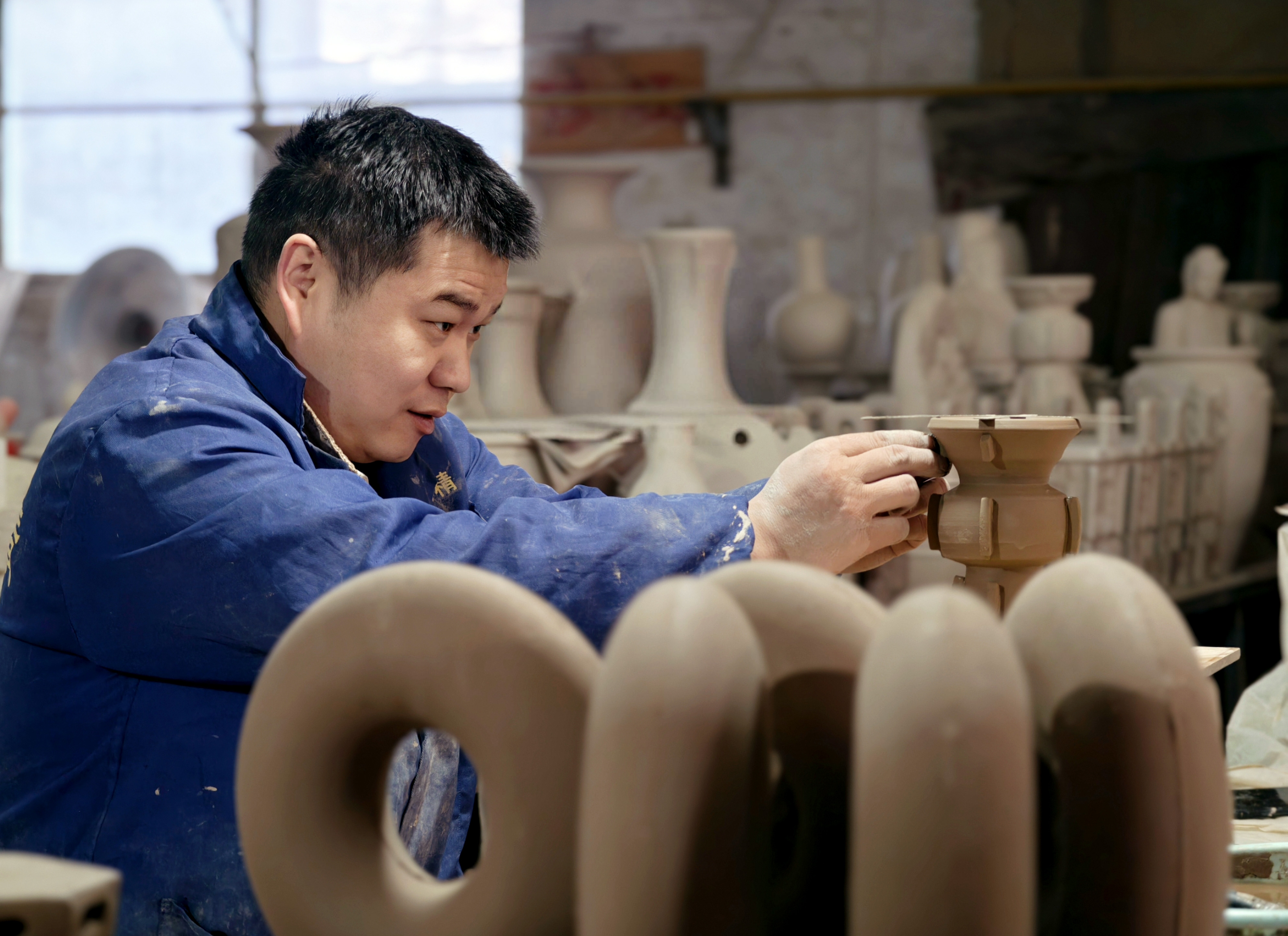 制瓷工坊内,匠人手拉坯制作。 制瓷工坊内,匠人手拉坯制作。
