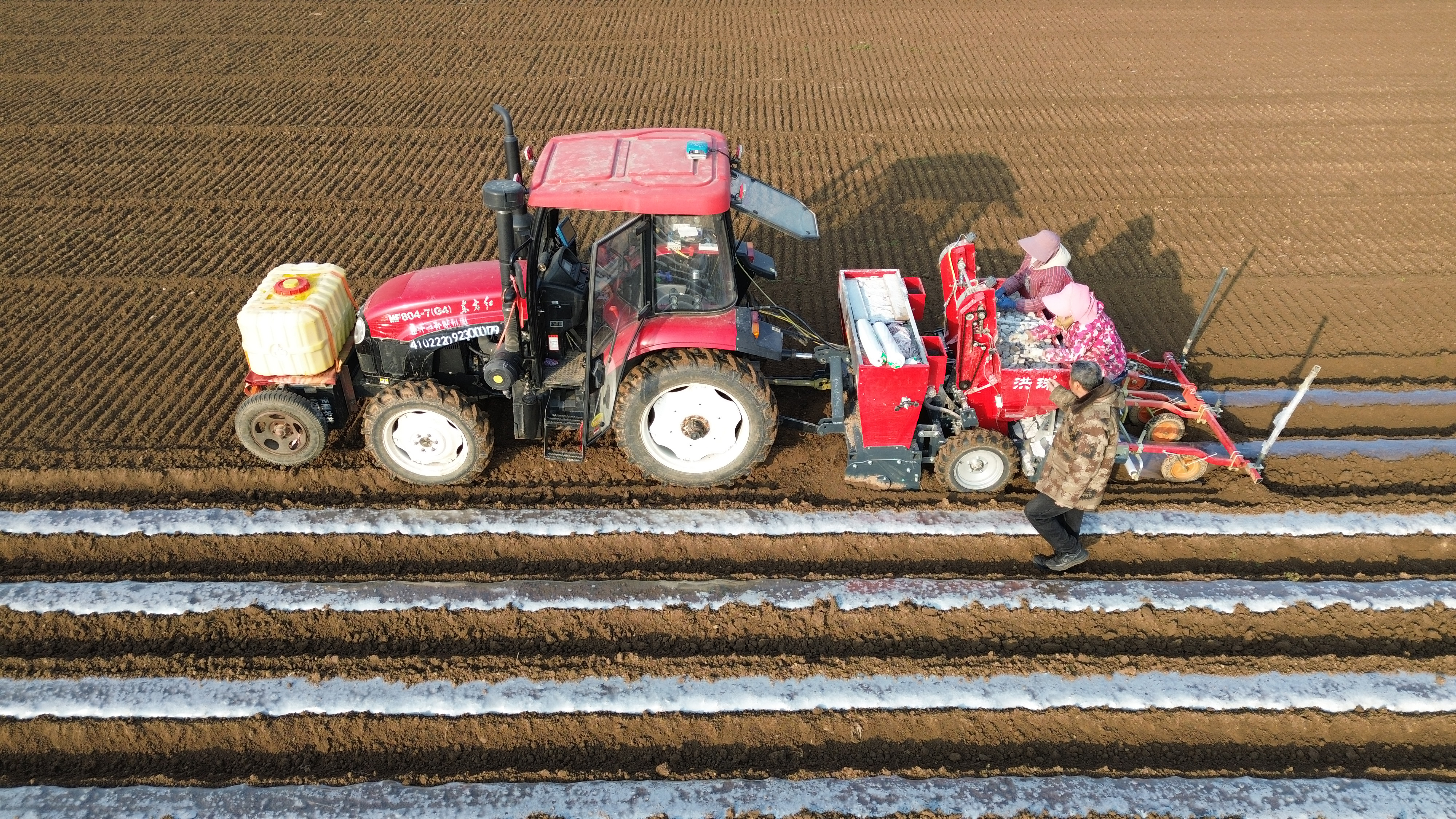 1月16日，鄢陵县马坊镇马坊集村村民操作机械设备播种马铃薯（无人机照片）。